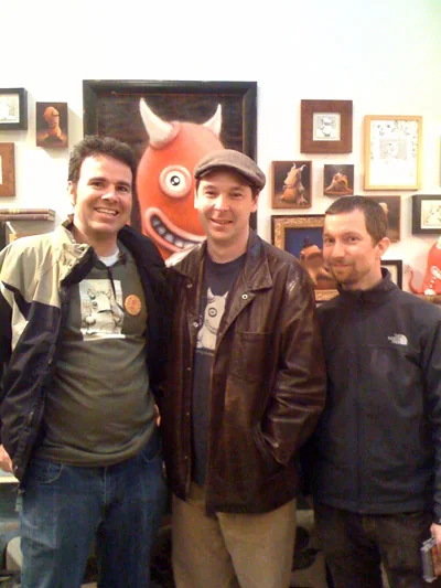 Kevin Kinell, Dylan Sisson, and Andrew Woods together at the Yipe! 5 launch party, with a large Idle Hands painting behind them.