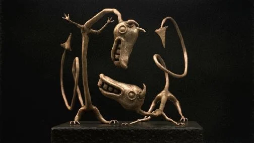 Posed study of two long, handmade-looking VR creatures rendered against black.