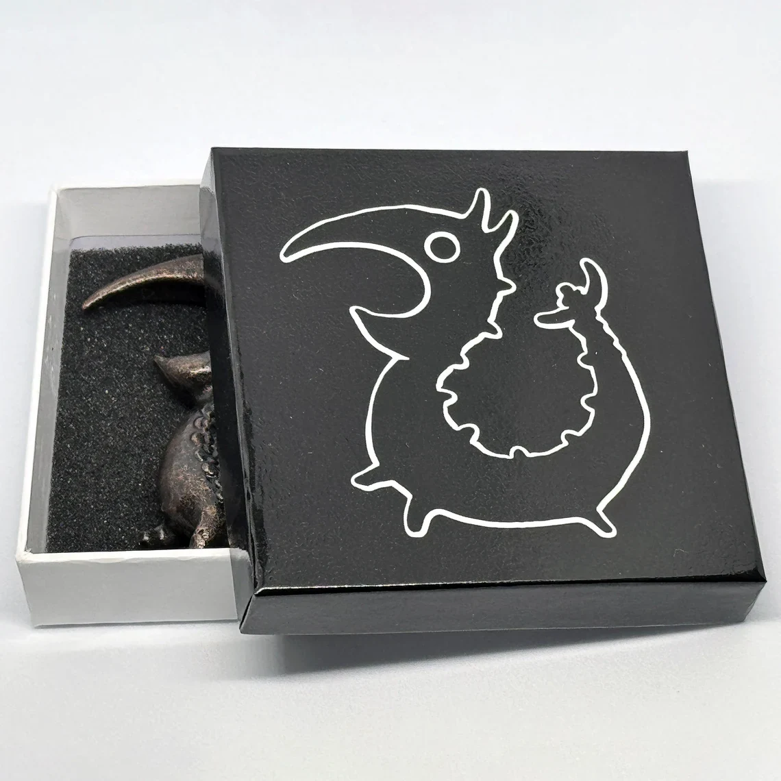 The Dragon Opener partly revealed inside its black presentation box.