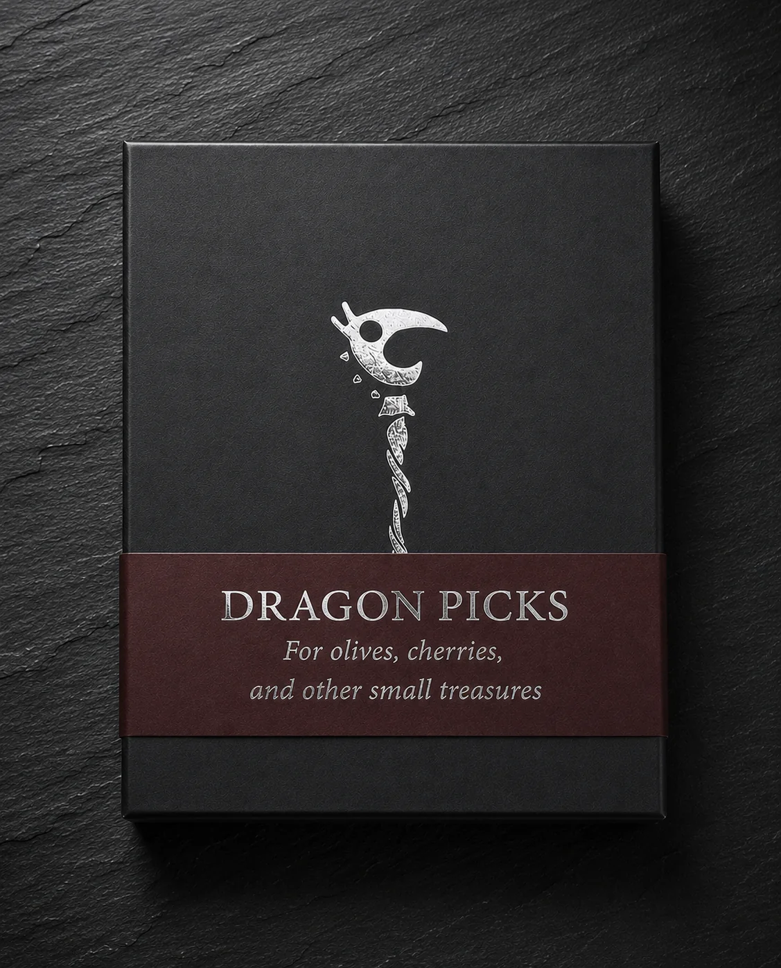 Handmade black Dragon Picks box sample with burgundy paper wrap and foil-stamped lettering.