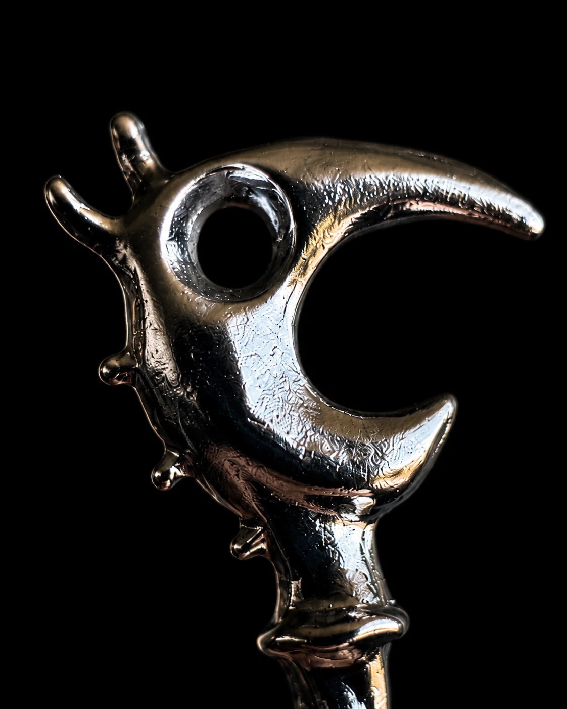 Close view of the chrome-plated dragon head showing its beak, eye opening, and textured surface.