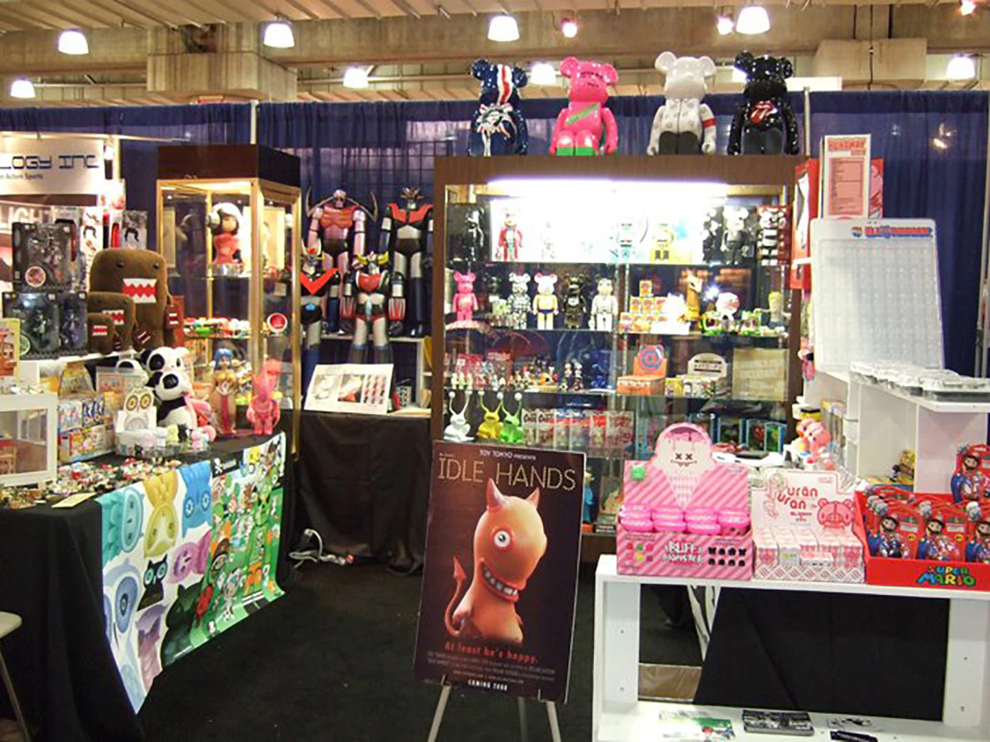 The crowded Toy Tokyo booth at New York Toy Fair 2008, with an Idle Hands announcement poster standing at the front.