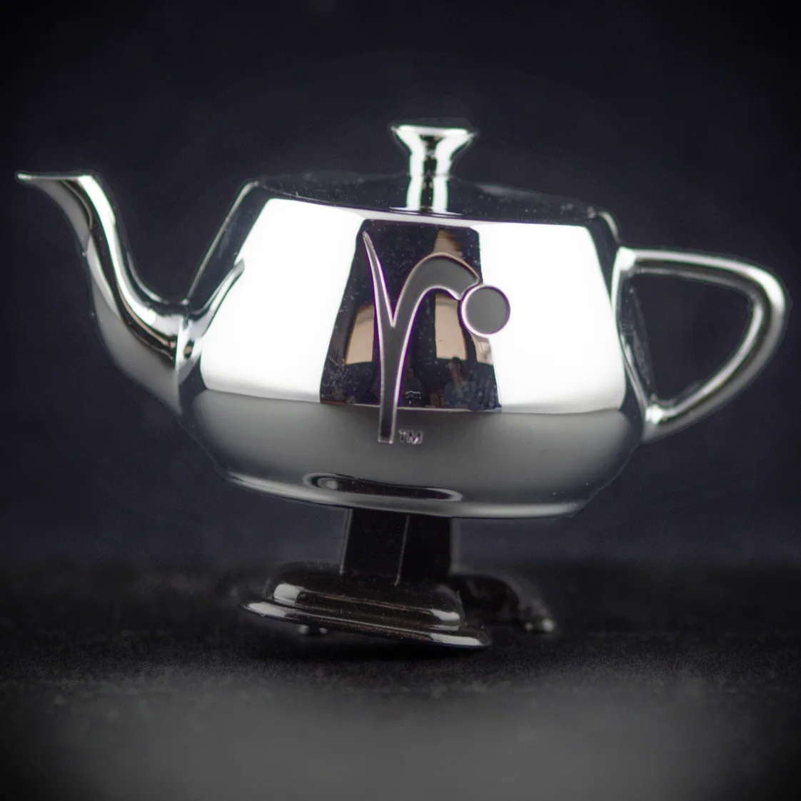 The original silver Walking Teapot photographed against black.